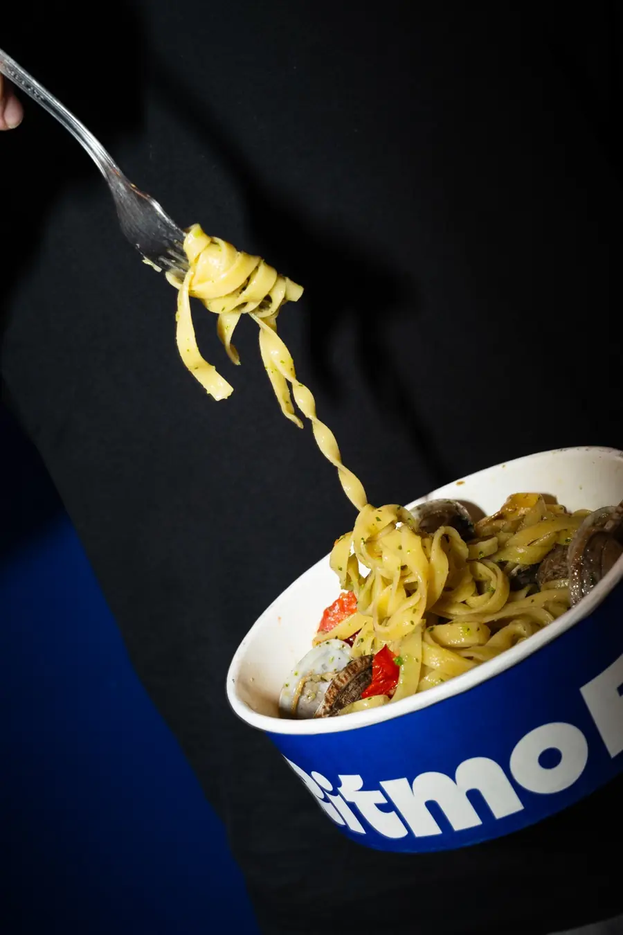 Tagliatelle enrolladas en un tenedor sobre un bol de Ritmo