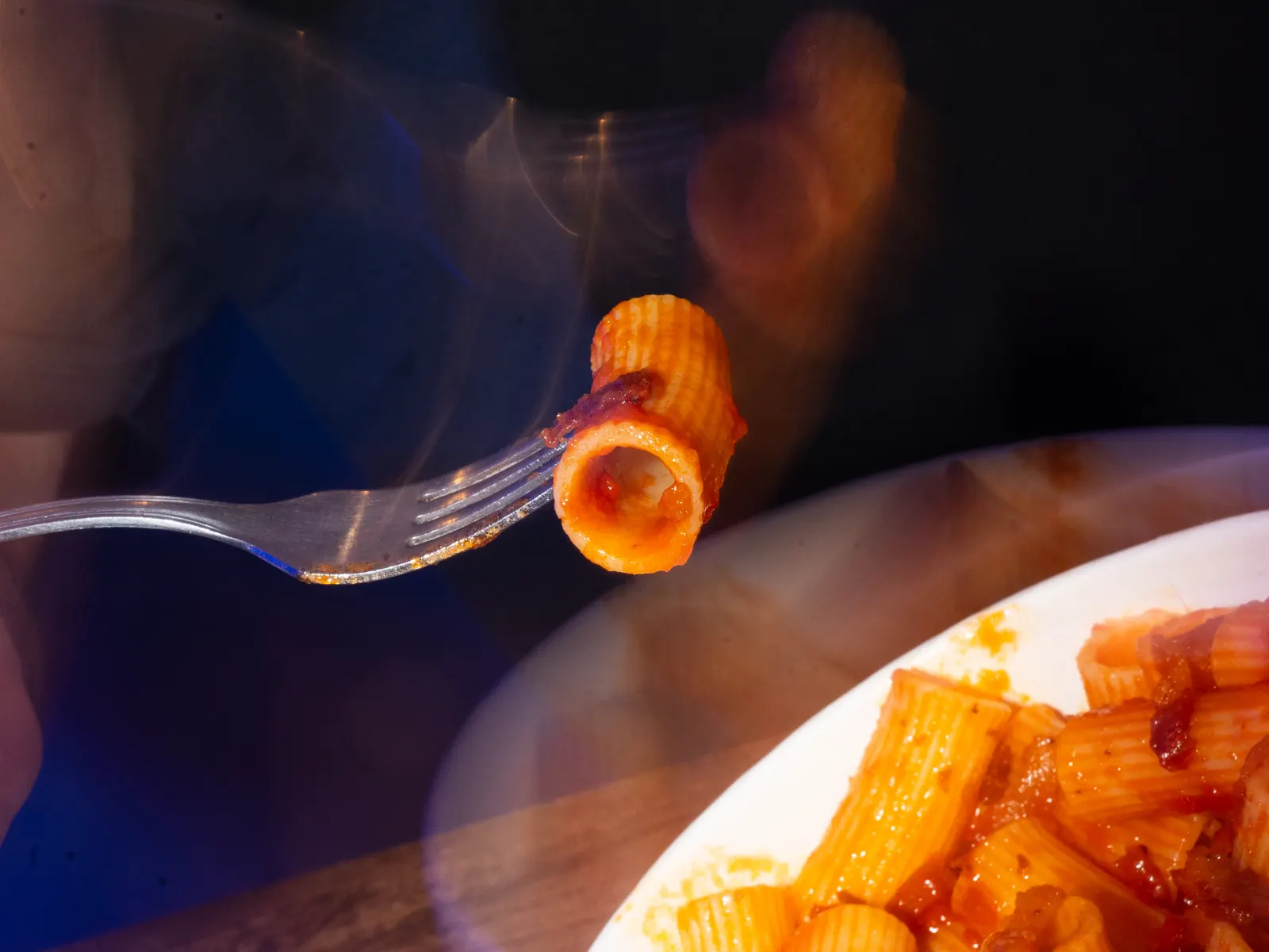 Rigatoni en un tenedor sobre un plato de Ritmo